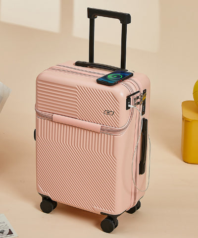 Pink hard-shell carry-on standing upright with a phone resting on its flat top panel