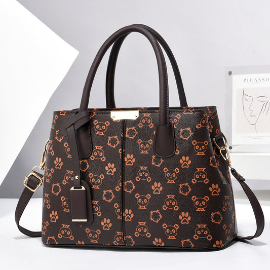 Brown handbag with a paw-print pattern and hanging tag charm